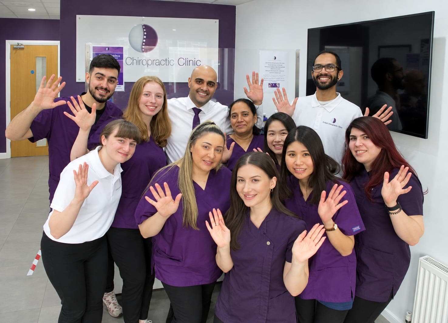 The Enfield Chiropractic Clinic team waving in the clinic's reception